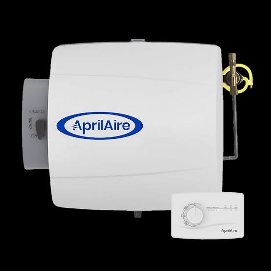 A white Aprilaire humidifier unit with a visible control dial and metallic valve, positioned on a black background.